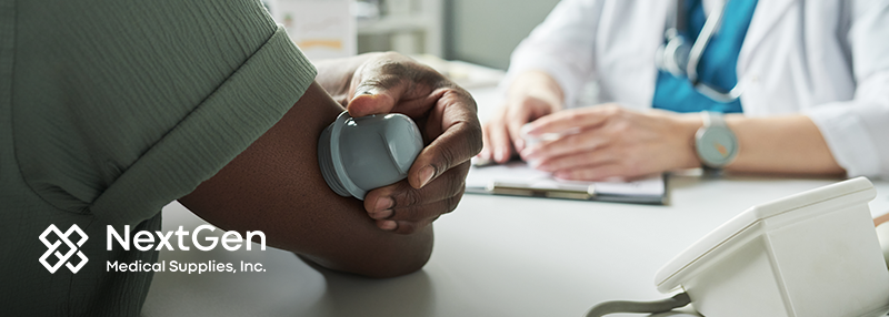 Person applying a continuous glucose monitor to their arm in front of a healthcare professional at their office