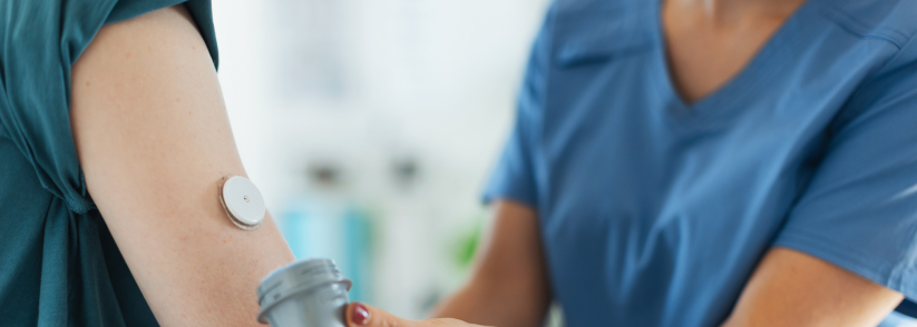 Nurse applying a continuous glucose monitor to the arm of a person