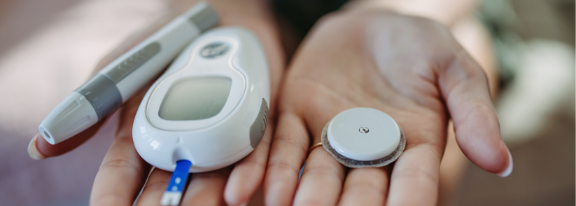 Close up of hands holding diabetes supplies and devices like a continuous glucose monitor, insulin pen, and blood glucose monitor.