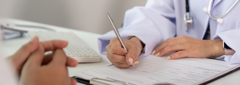 Healthcare professional filling out documentation at a desk