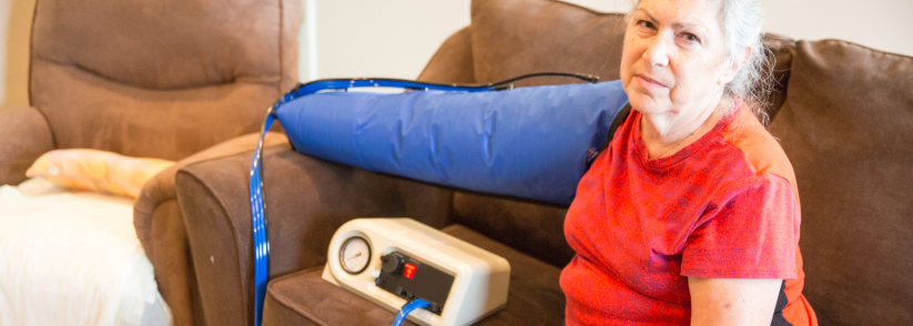 Older woman using an arm pump for home to treat lymphedema.